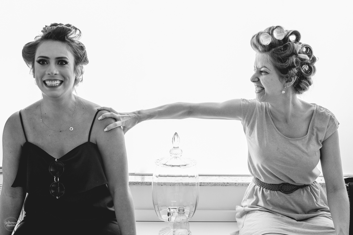 Fotografia de casamento pelo fotógrafo Guilherme Santos, noiva brincando com a madrinha nos preparativos do casamento,