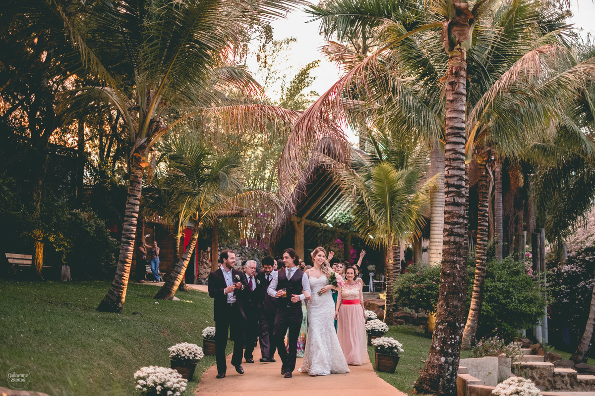 Fotografia de casamento feita no final de tarde pelo fotógrafo Guilherme Santos, convidados indo para festa de casamento ao ar livre em Botucatu.