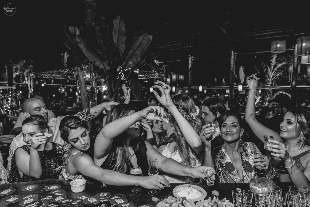 Fotografia de casamento pelo fotógrafo Guilherme Santos, noiva e madrinha bebendo tequila na festa de casamento animada em Botucatu.