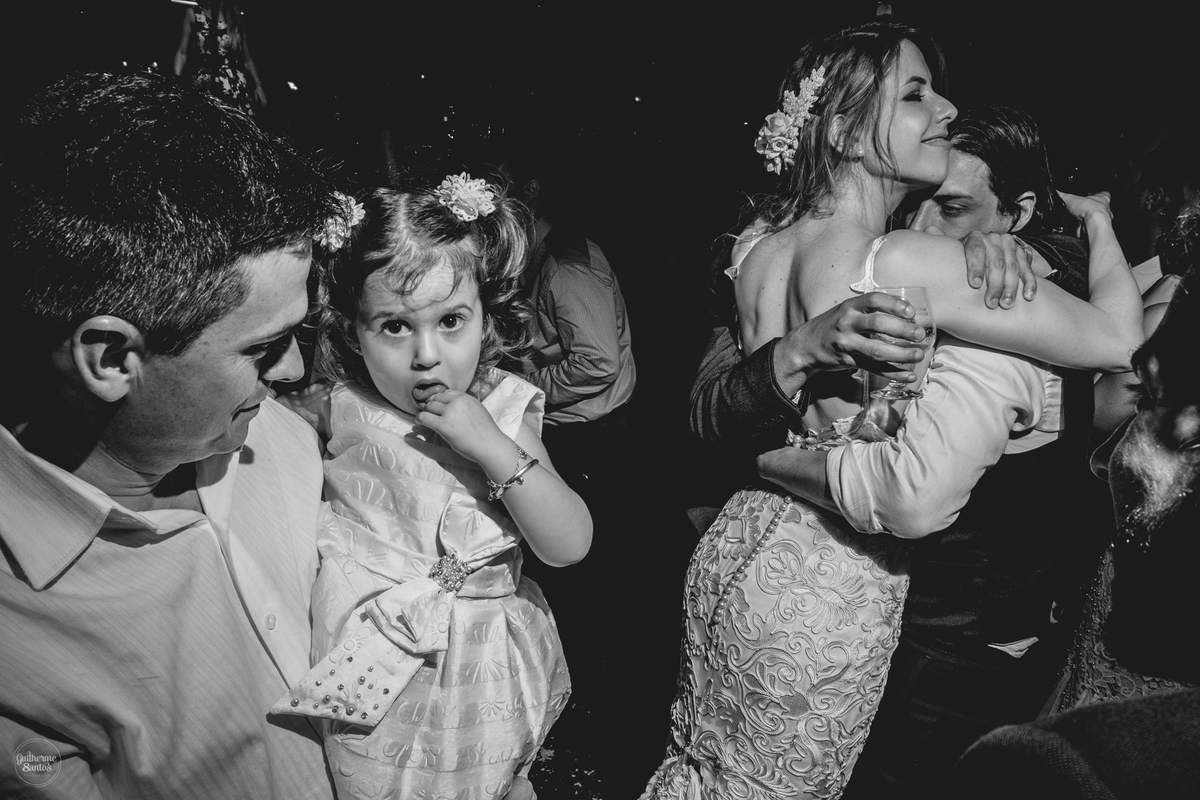 Fotografia de casamento pelo fotógrafo Guilherme Santos, casal de noivos se abraçando, criança está olhando para o fotógrafo.