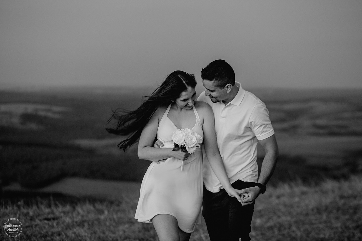 Fotografia de casamento pelo fotógrafo Guilherme Santos na região de Jaú Sp, Bauru Sp, sessão pre casamento com noivos caminhando e se abraçando com a vista para as montanhas.