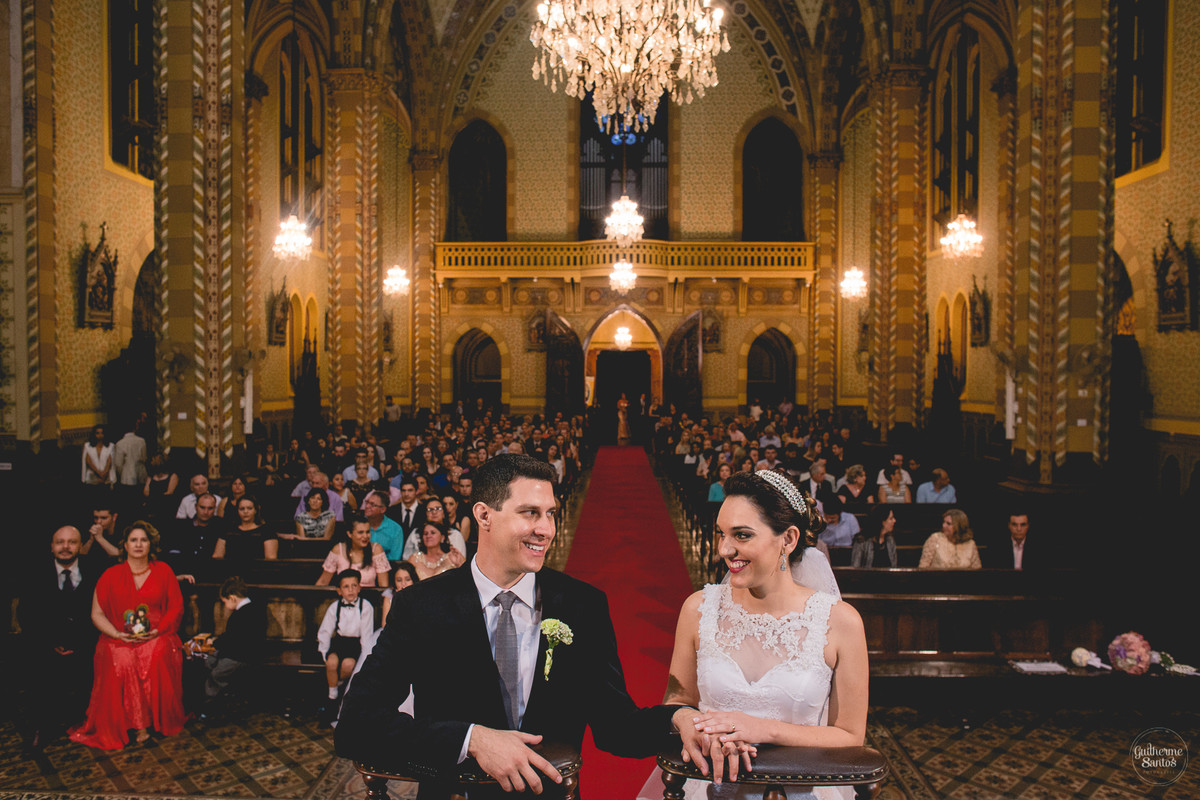 Fotografia de casamento pelo fotógrafo Guilherme Santos na região de Jaú Sp, Bauru Sp, cerimonia de casamento, noivos ajoelhados se olhando e sorrindo.