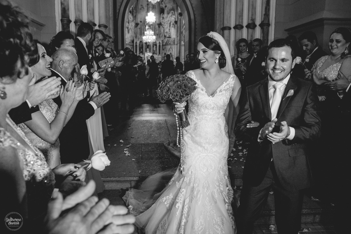 Fotografia de casamento pelo fotógrafo Guilherme Santos na região de Jaú Sp, Bauru Sp, cerimonia de casamento com os noivos comemorando com padrinhos na saida da igreja.