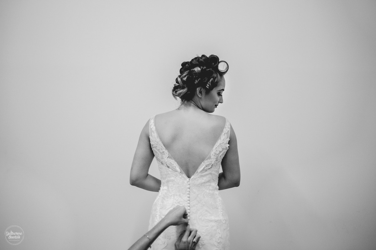 Fotografia de casamento pelo fotógrafo Guilherme Santos na região de Jaú Sp, Bauru Sp, noiva colocando o vestido em seu making os.