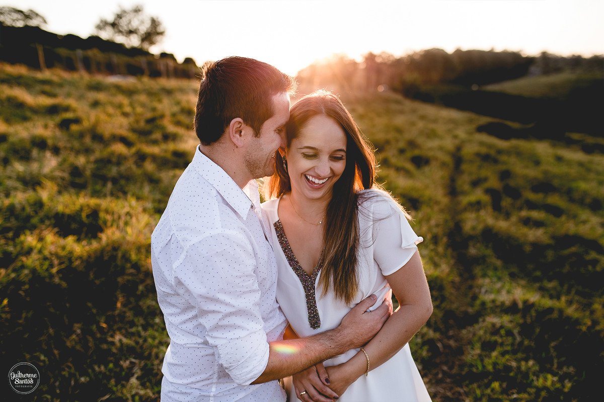 Fotografia de casamento pelo fotógrafo Guilherme Santos na região de Jaú Sp, Bauru Sp, sessão pre casamento com noivos abraçados, sorrindo com um lindo por do sol.