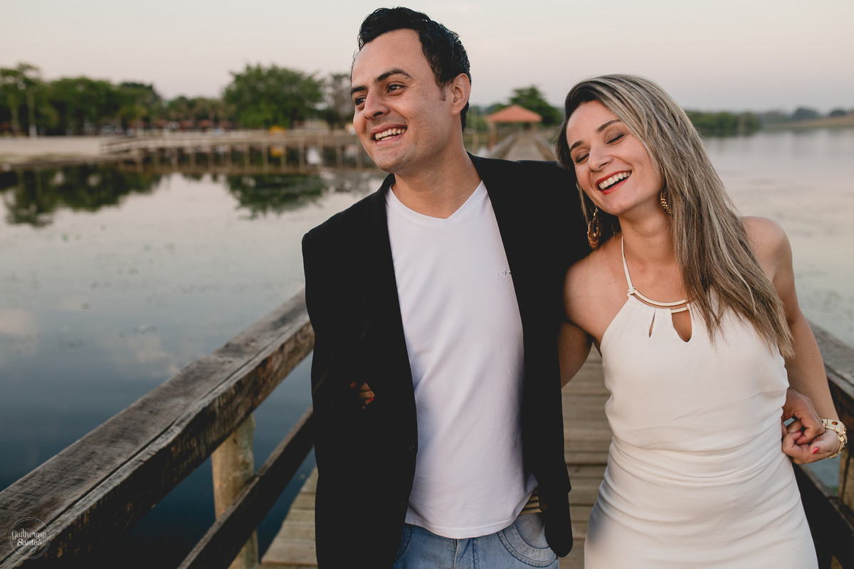 Ensaio pré casamento de Guilherme Santos Fotografia que rolou na Arealva – SP, sessão fotográfica no nascer do sol. Noivos sorrindo e caminhando em um deck proximo ao rio, uma paisagem linda.