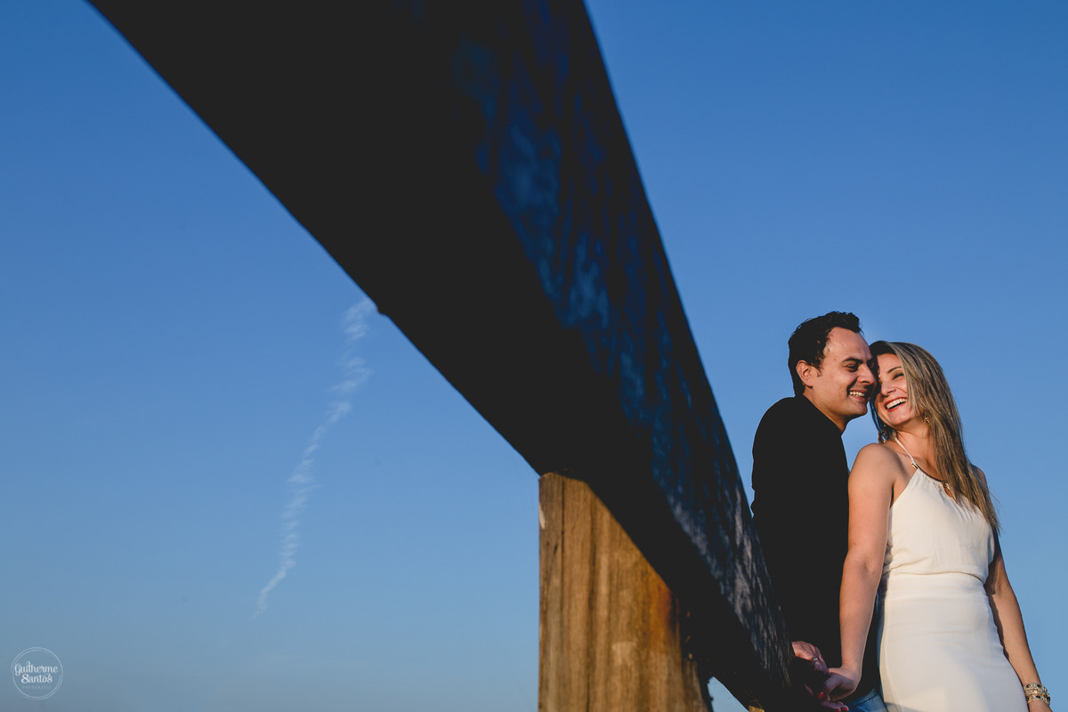 Ensaio pré casamento de Guilherme Santos Fotografia que rolou na Arealva – SP, sessão fotográfica no nascer do sol. Noivos se abraçando e sorrindo em um deck proximo ao rio, uma paisagem linda.