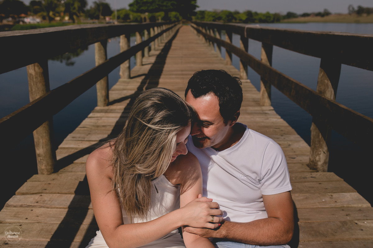 Ensaio pré casamento de Guilherme Santos Fotografia que rolou na Arealva – SP, sessão fotográfica no nascer do sol. Noivos se abraçando e sorrindo em um deck proximo ao rio, uma paisagem linda.