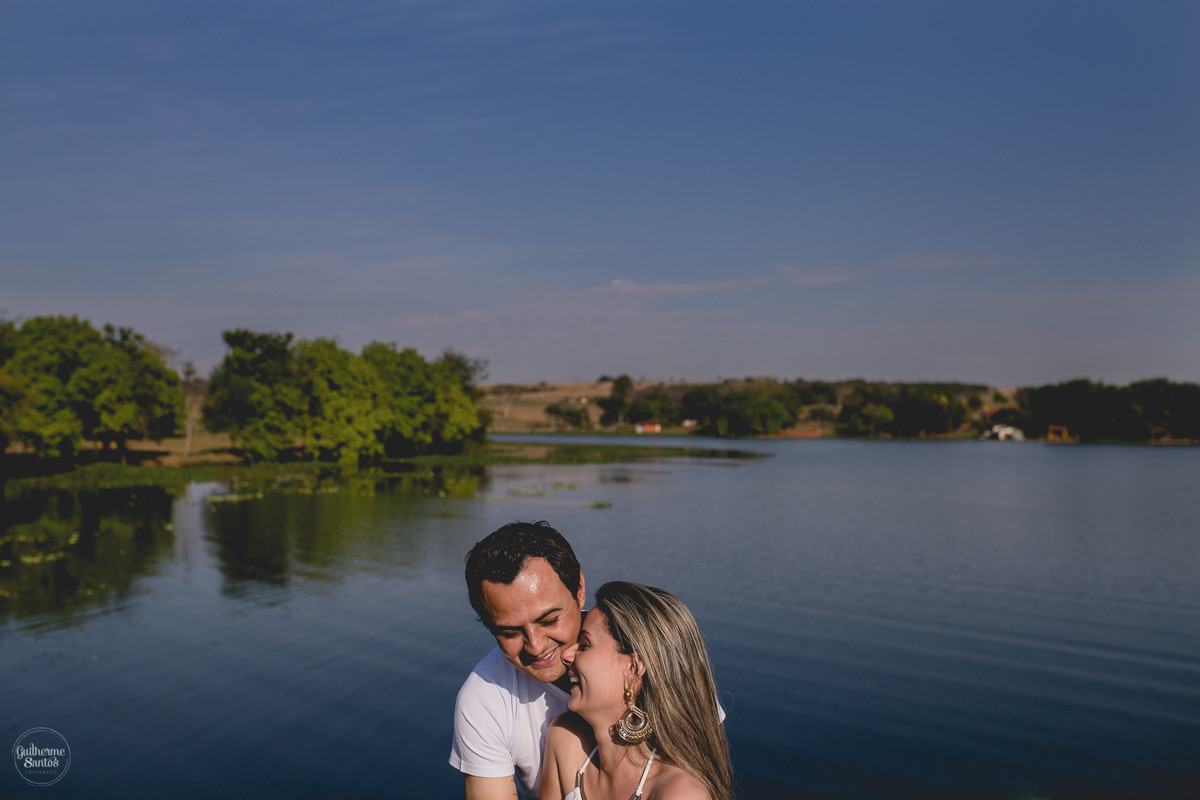 Ensaio pré casamento de Guilherme Santos Fotografia que rolou na Arealva – SP, sessão fotográfica no nascer do sol. Noivos se abraçando e sorrindo em um deck proximo ao rio, uma paisagem linda.