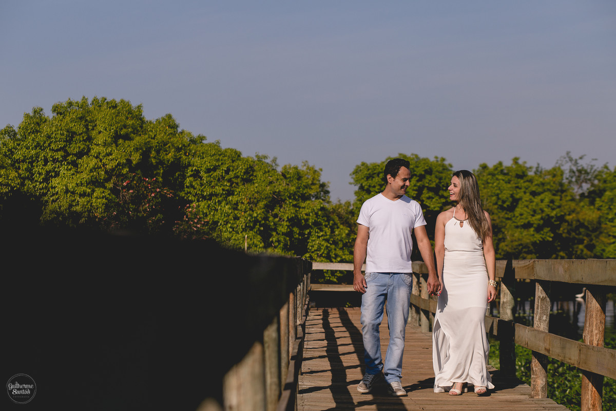 Ensaio pré casamento de Guilherme Santos Fotografia que rolou na Arealva – SP, sessão fotográfica no nascer do sol. Noivos sorrindo e caminhando em um deck proximo ao rio, uma paisagem linda.