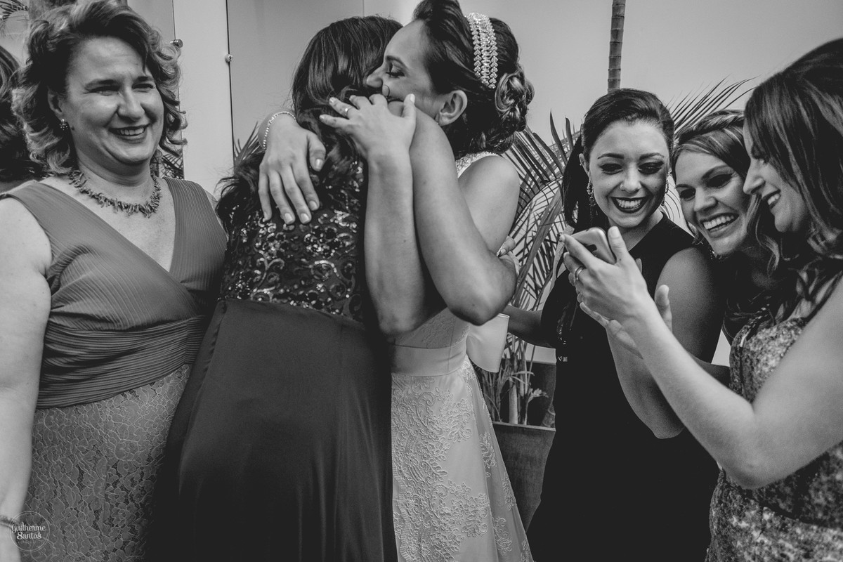 Fotografia de casamento pelo fotógrafo Guilherme Santos, noiva abraçando as amigas em festa de casamento