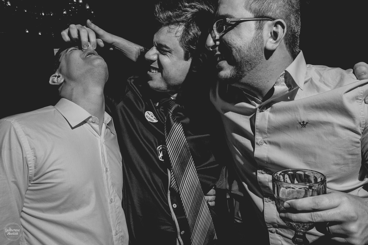 Fotografia de casamento pelo fotógrafo Guilherme Santos, noivo curtindo e cantando com os amigos em festa de casamento