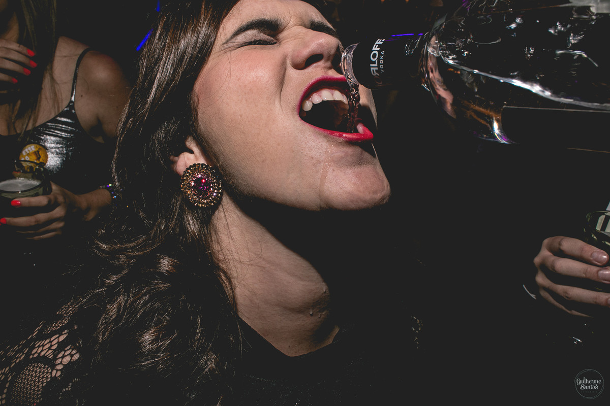 Fotografia de casamento pelo fotógrafo Guilherme Santos, amiga nos noivos virando bebida em festa de casamento
