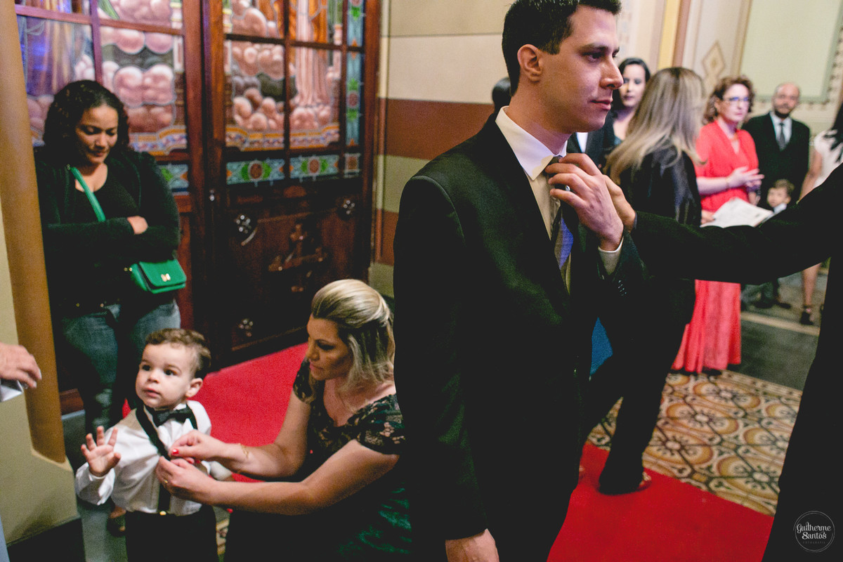 Fotografia de casamento pelo fotógrafo Guilherme Santos, noivo e os convidados na porta da igreja