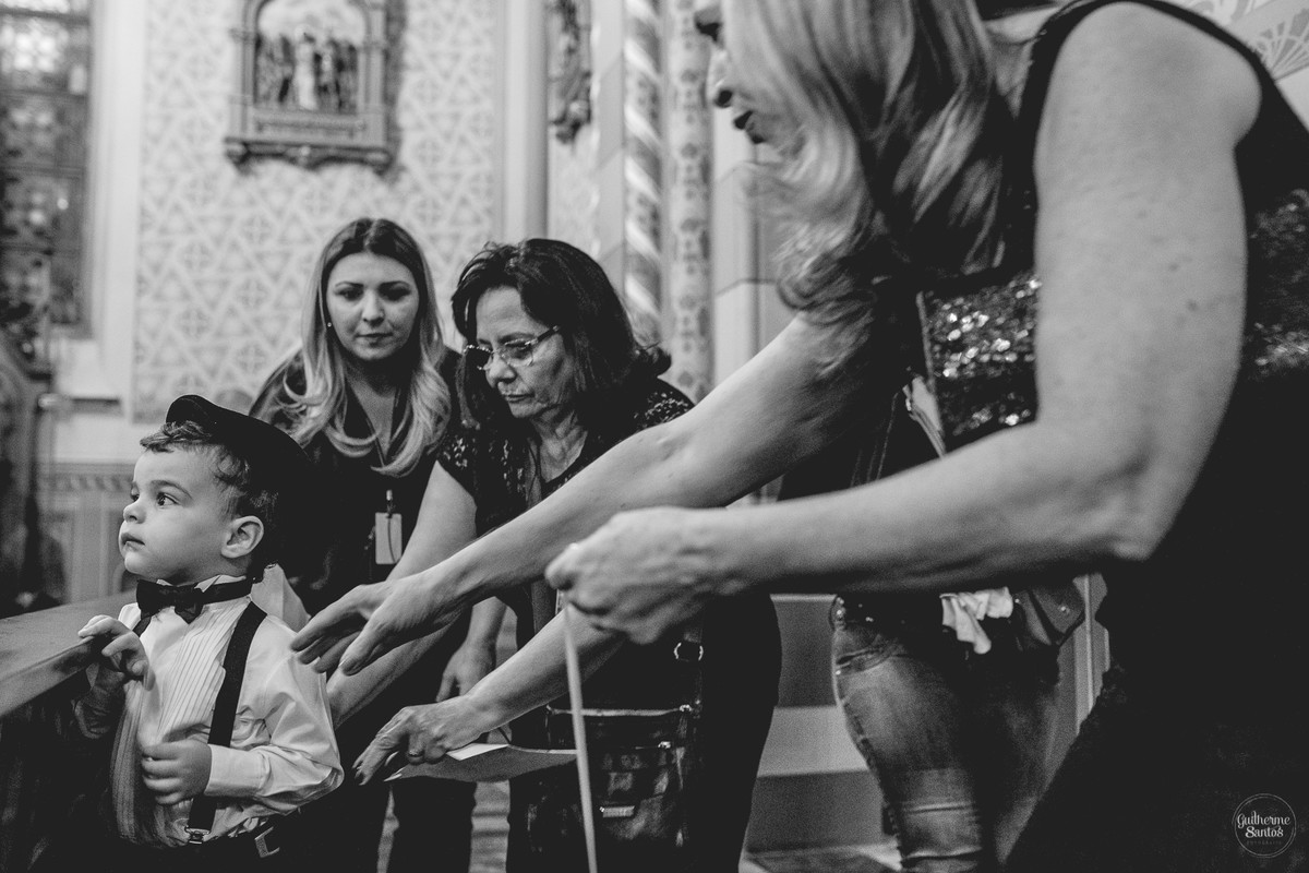 Fotografia de casamento pelo fotógrafo Guilherme Santos, cerimonialistas correndo atrais do pajem na porta da igreja antes da cerimonia