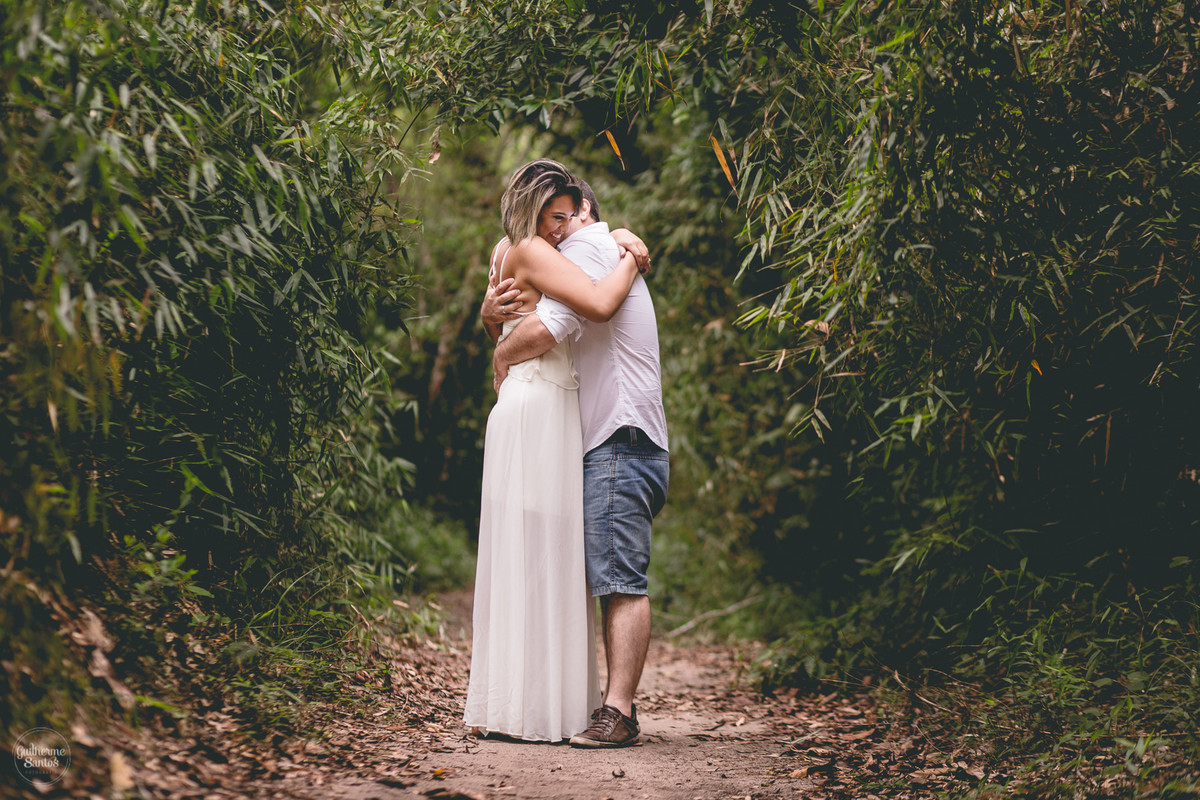 Ensaio pré casamento de Guilherme Santos Fotografia que rolou na Sengés-PR, sessão fotográfica no final de tarde. Noivos abraçados e sorrindo em uma trilha de mata fechada.