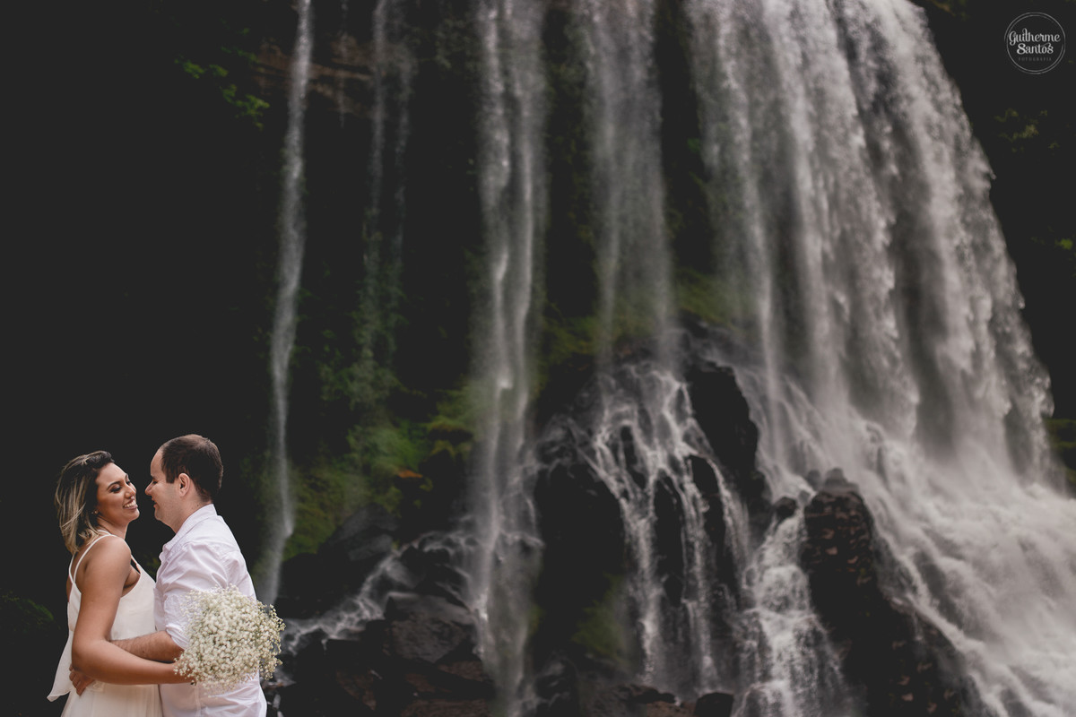 Ensaio pré casamento de Guilherme Santos Fotografia que rolou na Sengés-PR, sessão fotográfica no final de tarde. Noivos abraçados e sorrindo em uma cachoeira.