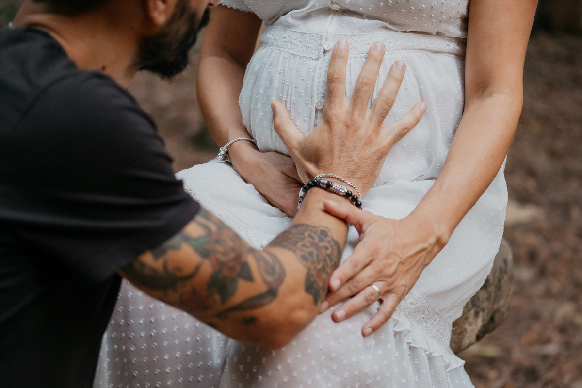pai com a mão na barriga da grávida