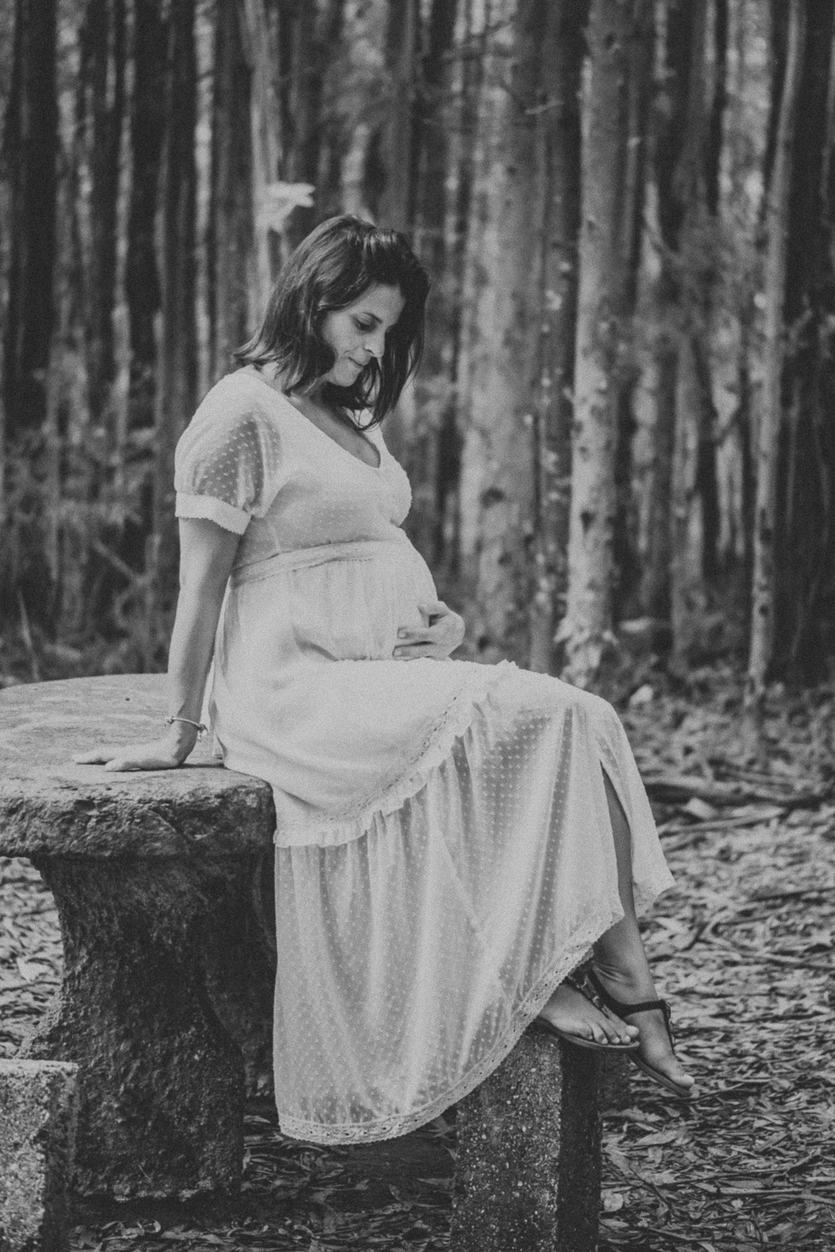 grávida sentada a olhar para a barriga