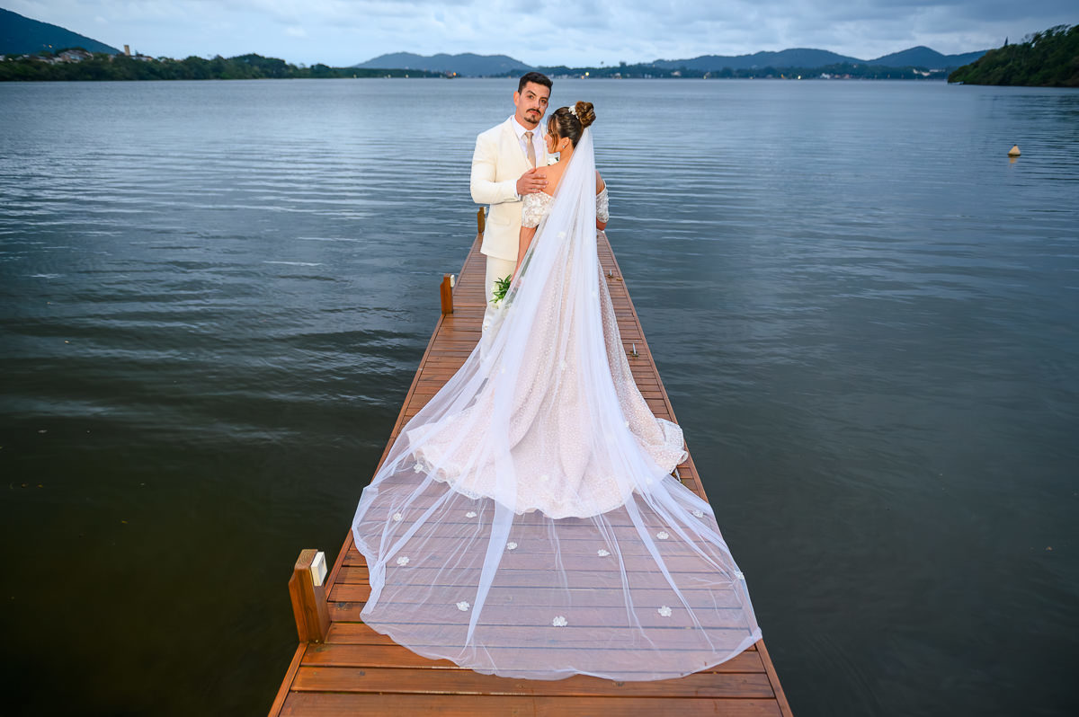 Carolina e Bruno no deck do Indaiá Eventos com a Lagoa da Conceição ao fundo
