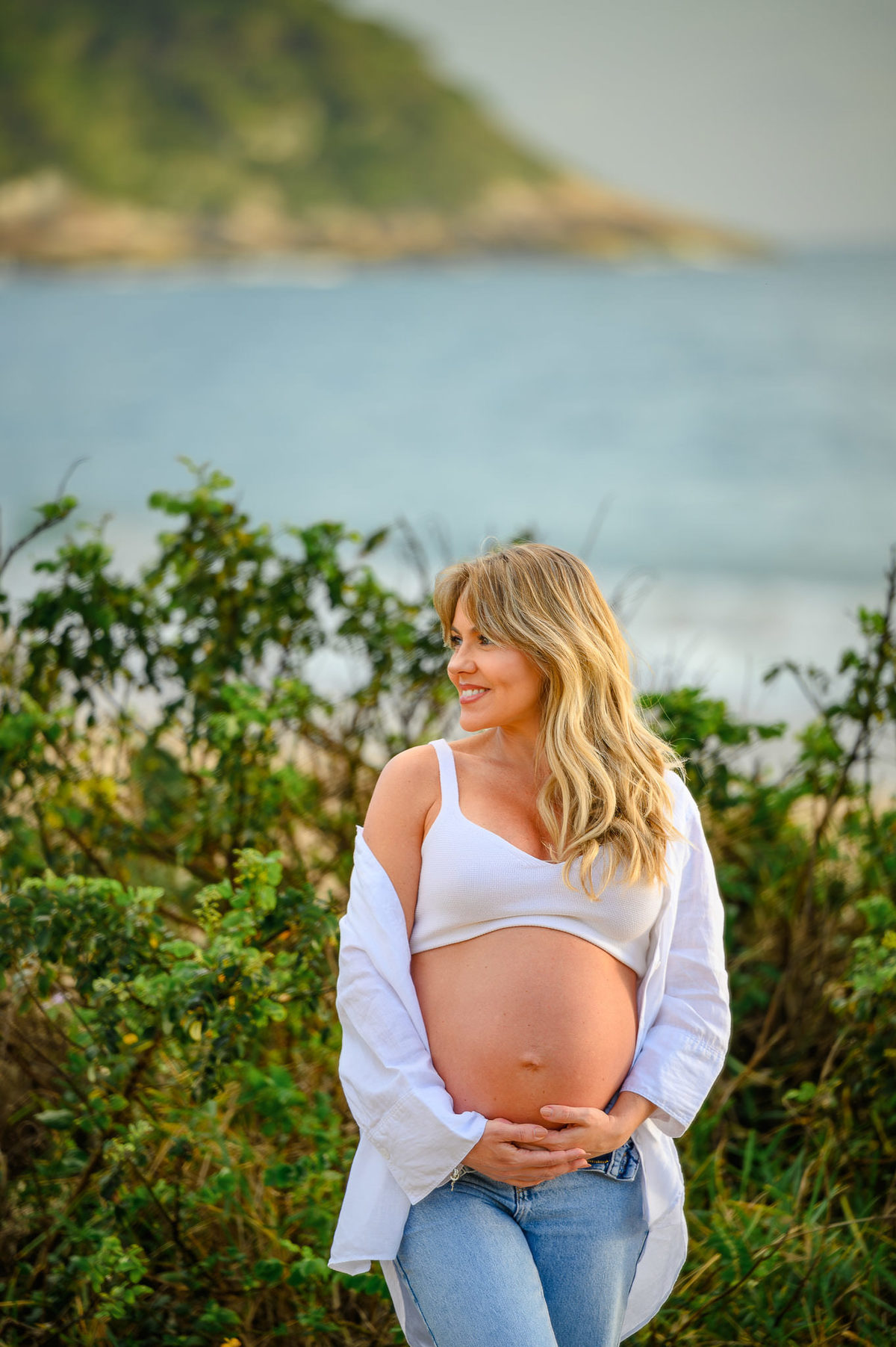 Fotografia de gestante em cenário de praia ao amanhecer em Balneário Camboriú, com casal em momento espontâneo.