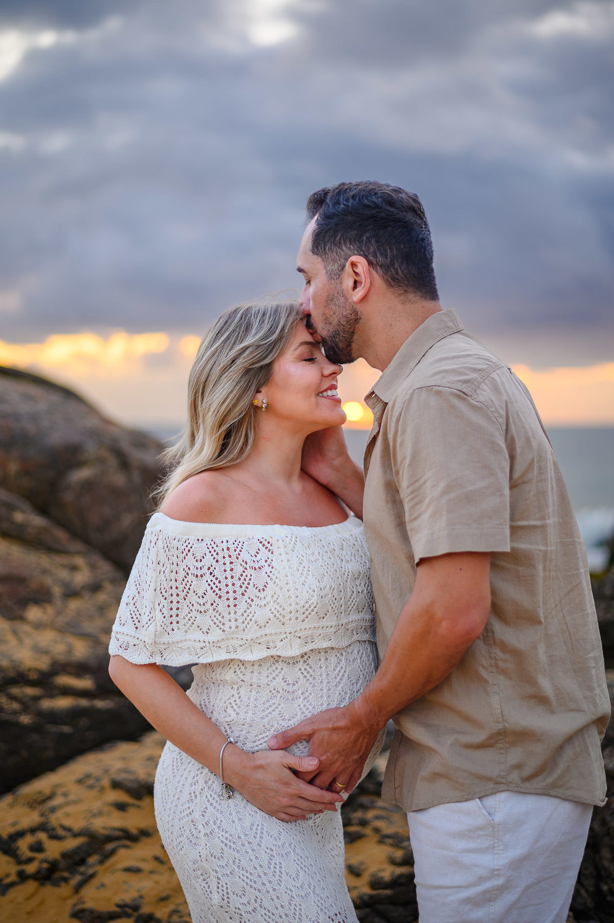 Ensaio gestante na praia ao amanhecer em Santa Catarina, com casal de mãos dadas diante do mar.