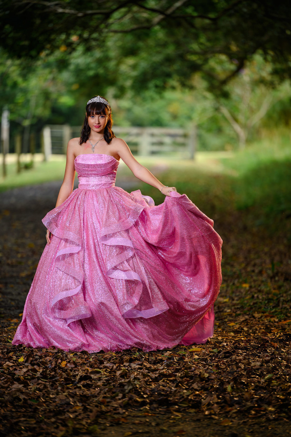 Ensaio fotográfico de 15 anos em Balneário Camboriú com debutante em vestido longo rosa em meio à natureza