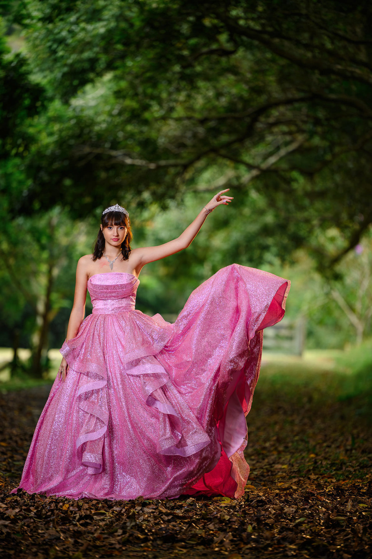 Ensaio fotográfico de 15 anos em Balneário Camboriú com debutante em vestido longo rosa em meio à natureza