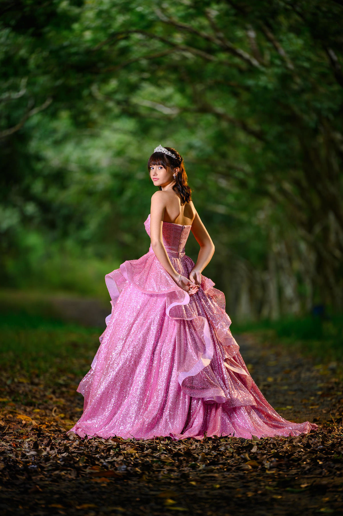 Ensaio de debutante em Balneário Camboriú com vestido rosa em cenário de bosque fechado