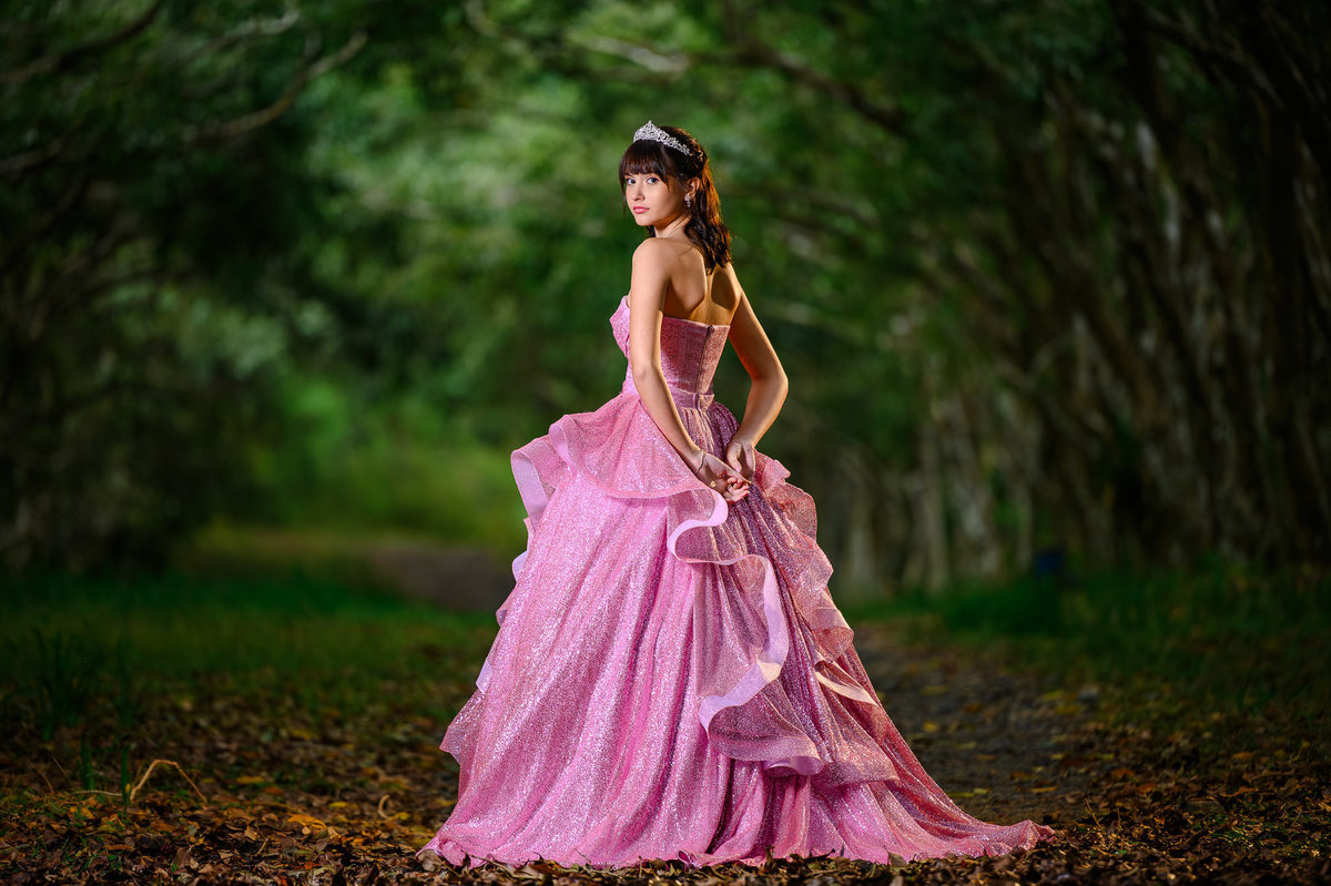 Ensaio de debutante em Balneário Camboriú com vestido rosa em cenário de bosque fechado