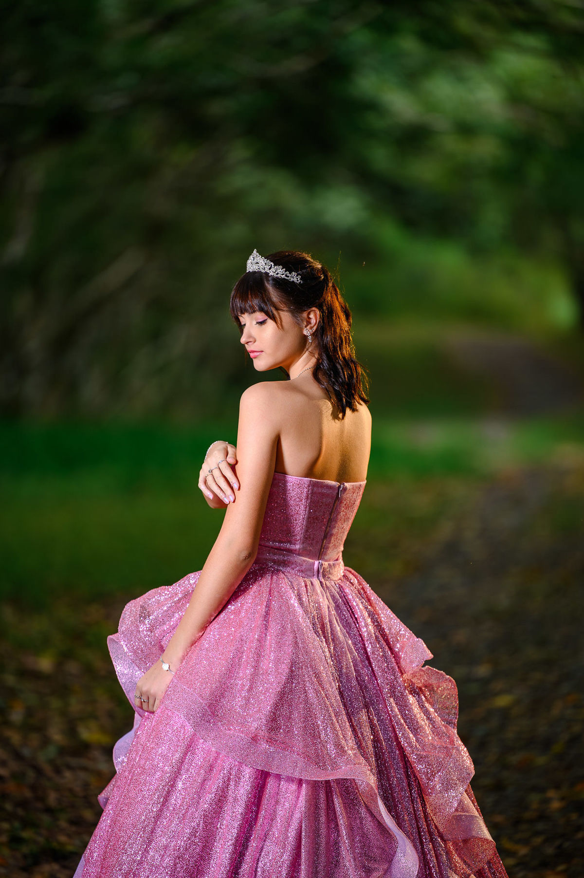 Retrato de 15 anos em Balneário Camboriú com debutante em bosque, luz suave e fundo desfocado