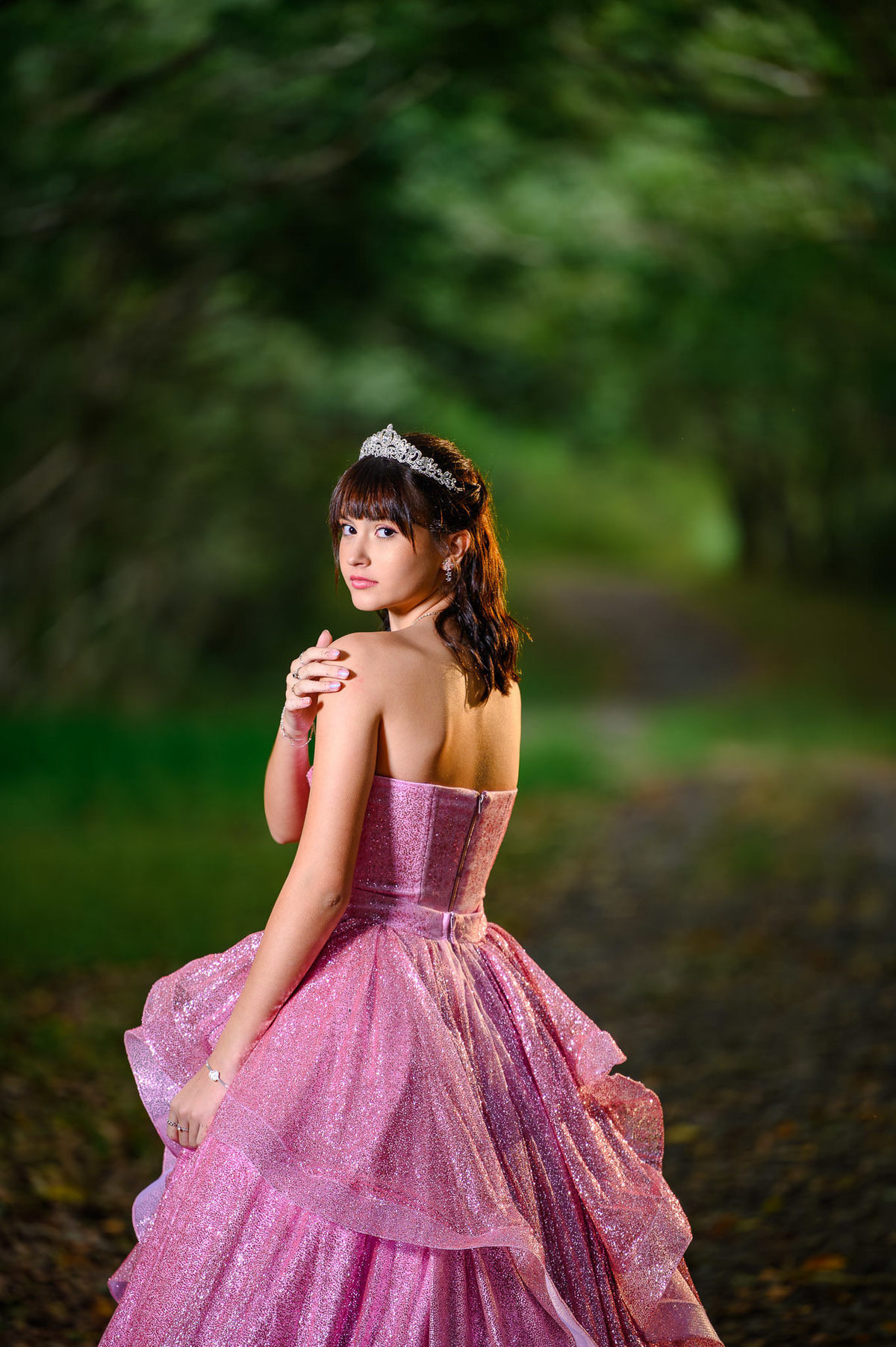 Retrato de 15 anos em Balneário Camboriú com debutante em bosque, luz suave e fundo desfocado