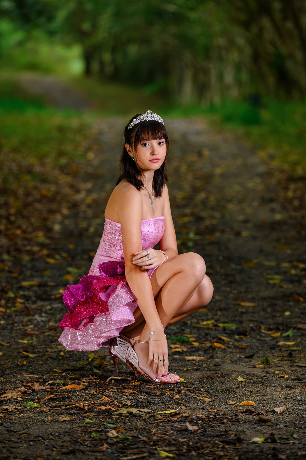 Fotografia de debutante em Balneário Camboriú em bosque, ensaio de 15 anos com vestido rosa em ambiente verde