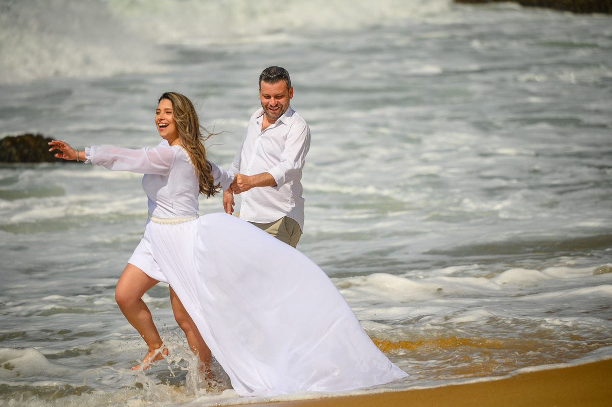 Ensaio pré-wedding com casal brincando com a água do mar na praia em SC
