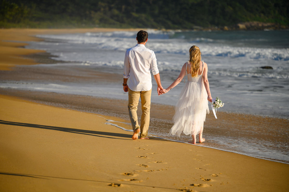 Casal caminhando na praia durante ensaio pré-wedding em Balneário Camboriú
