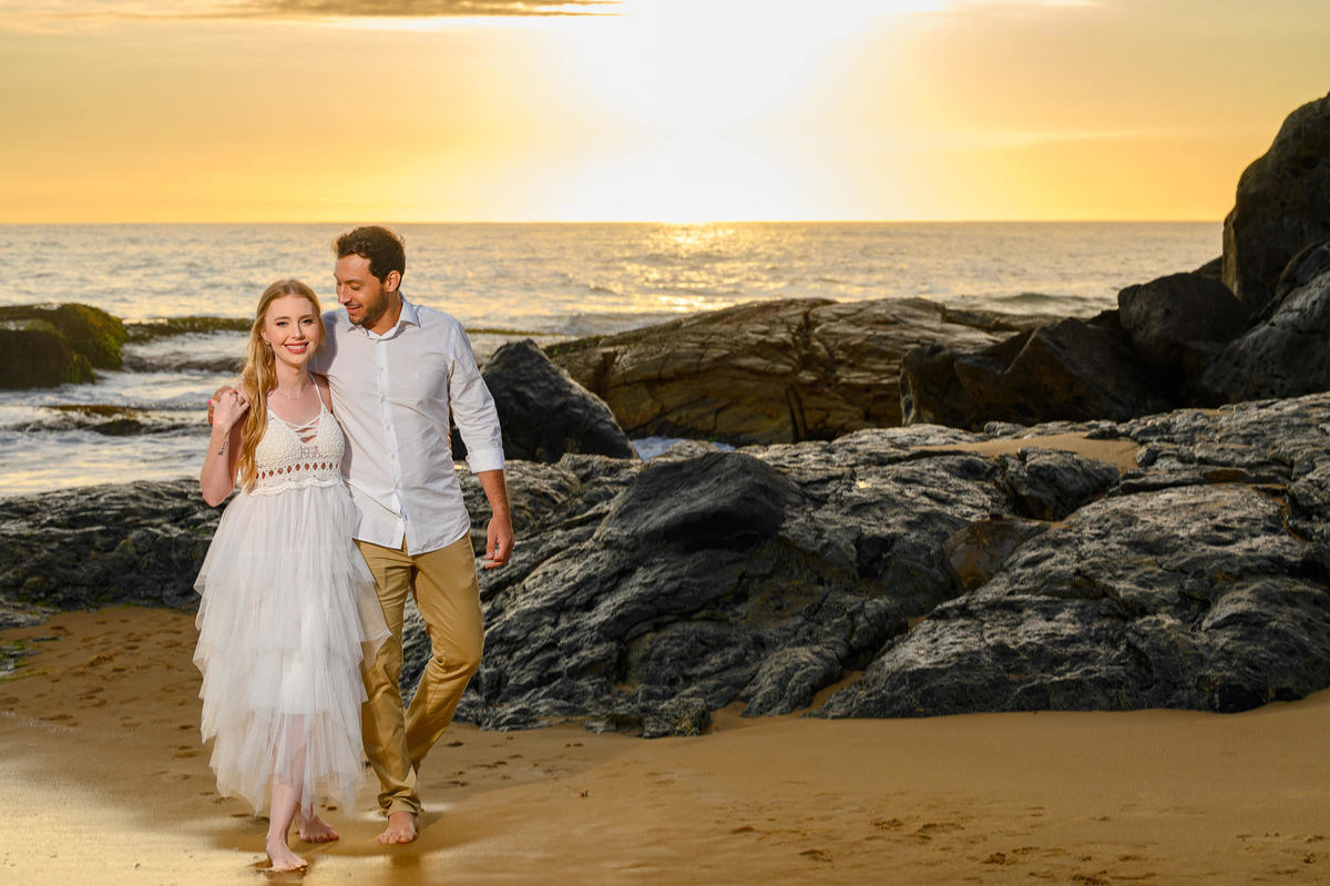 Casal caminhando na praia durante ensaio pré-wedding em Balneário Camboriú