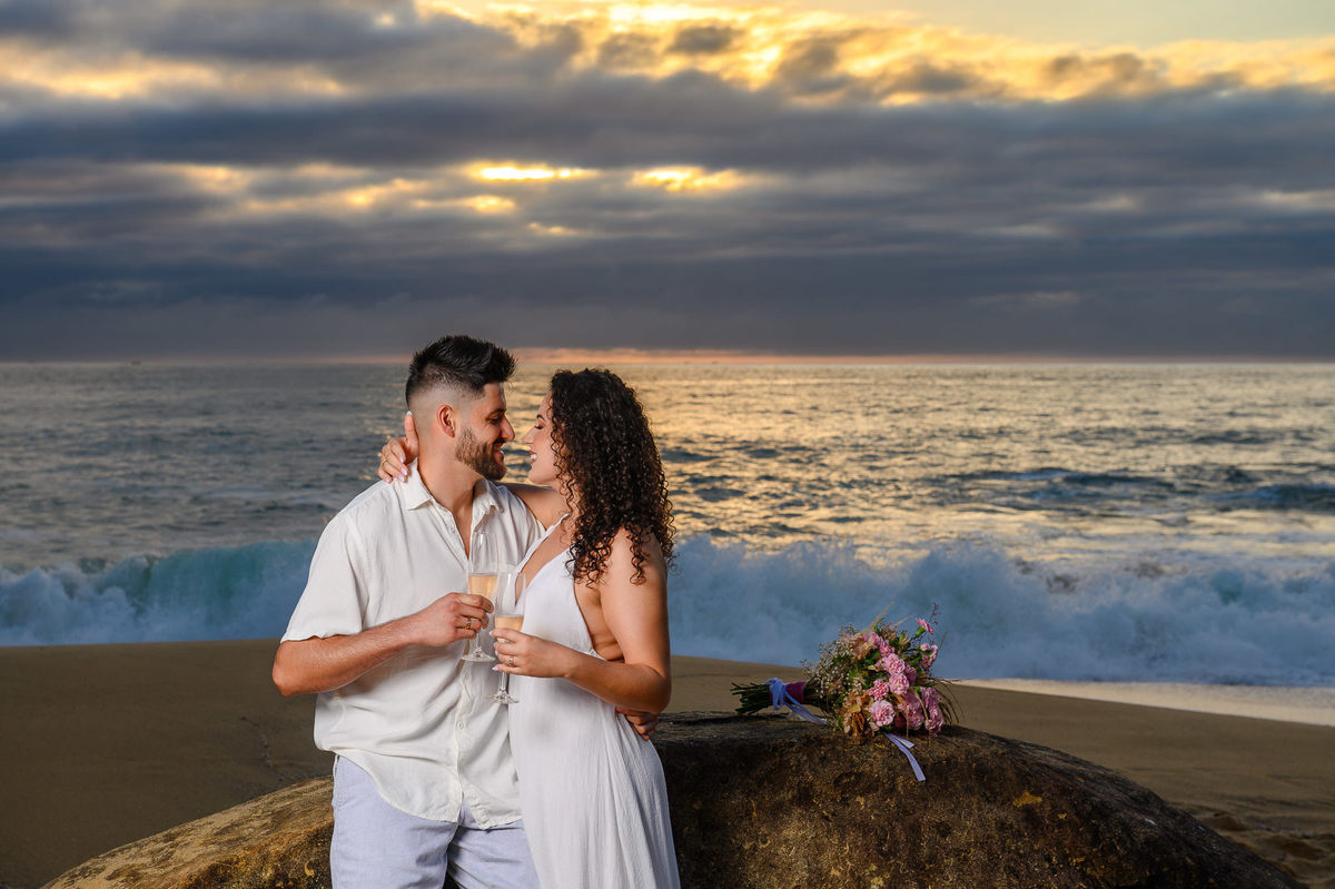 casal brindando com espumante durante pre wedding na Praia de Taquarinhas em SC