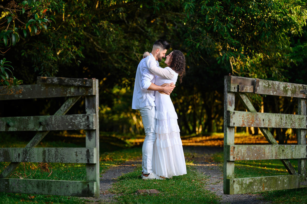 casal abraçado em caminho cercado por natureza durante ensaio pré wedding
