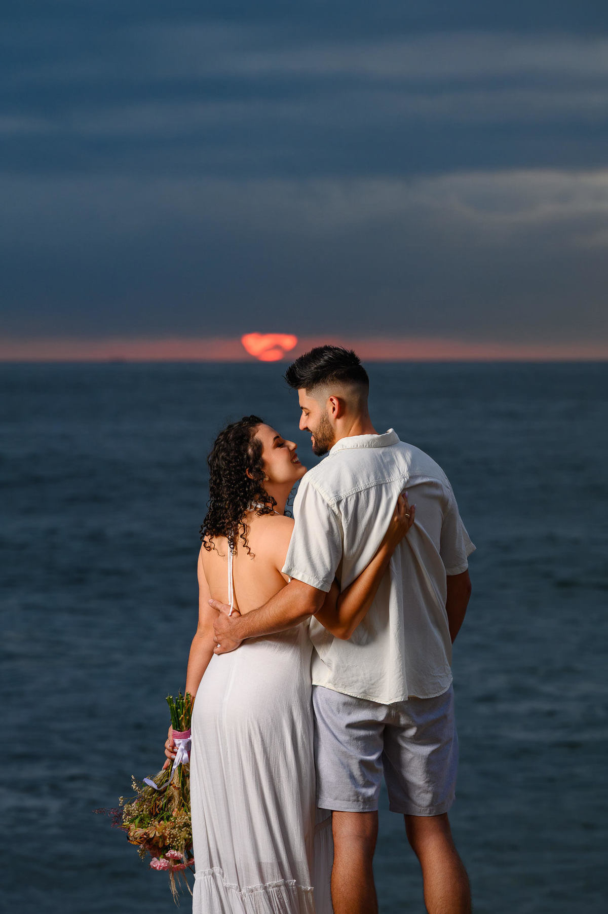 casal abraçado olhando o mar durante pre wedding em Balneário Camboriú Santa Catarina