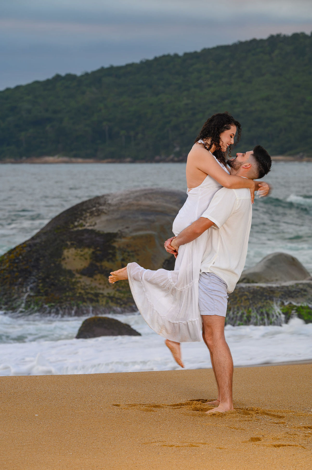 noiva sendo levantada pelo noivo durante ensaio de casal na praia em Balneário Camboriú