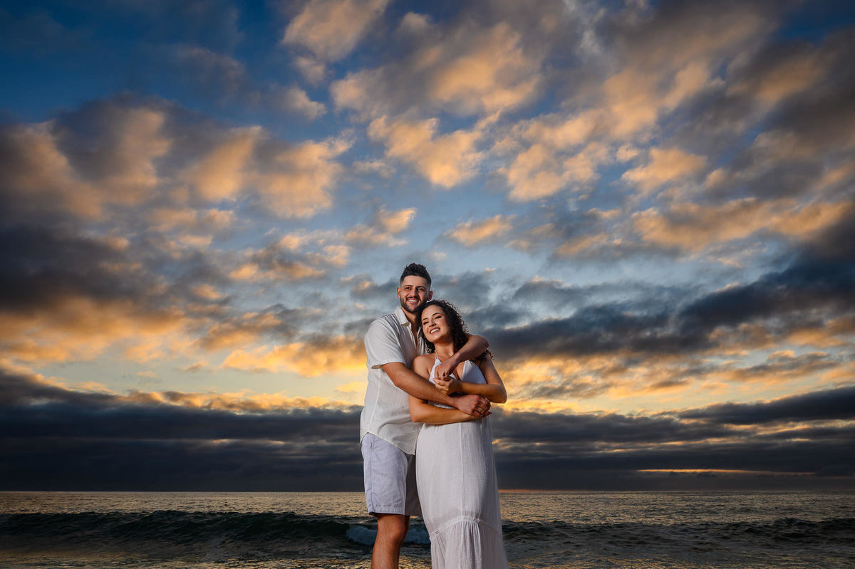 casal em retrato romântico com o mar ao fundo em pre wedding na Praia de Taquarinhas