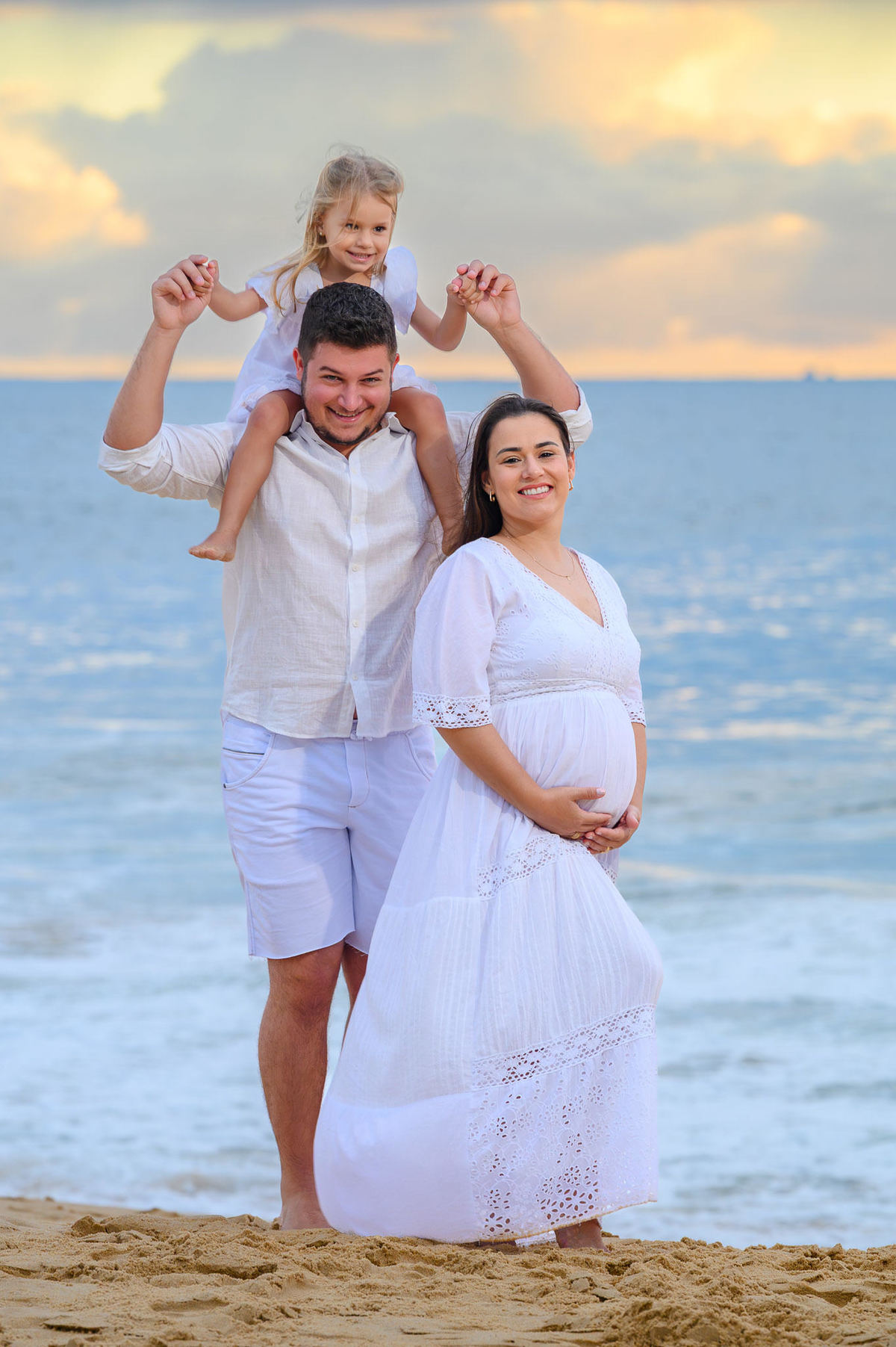 Gestante com família em ensaio fotográfico na praia