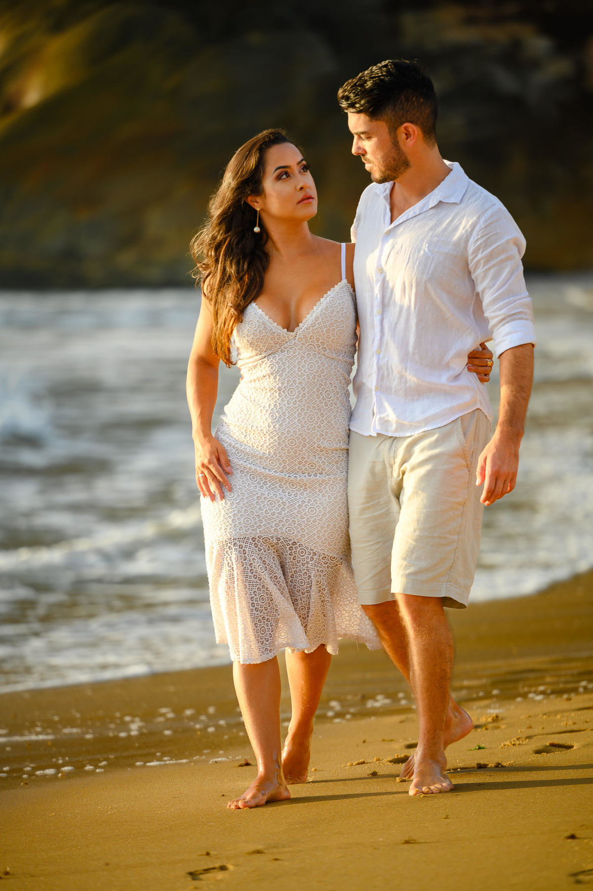 Casal caminhando na praia ao nascer do sol em ensaio fotográfico em Santa Catarina