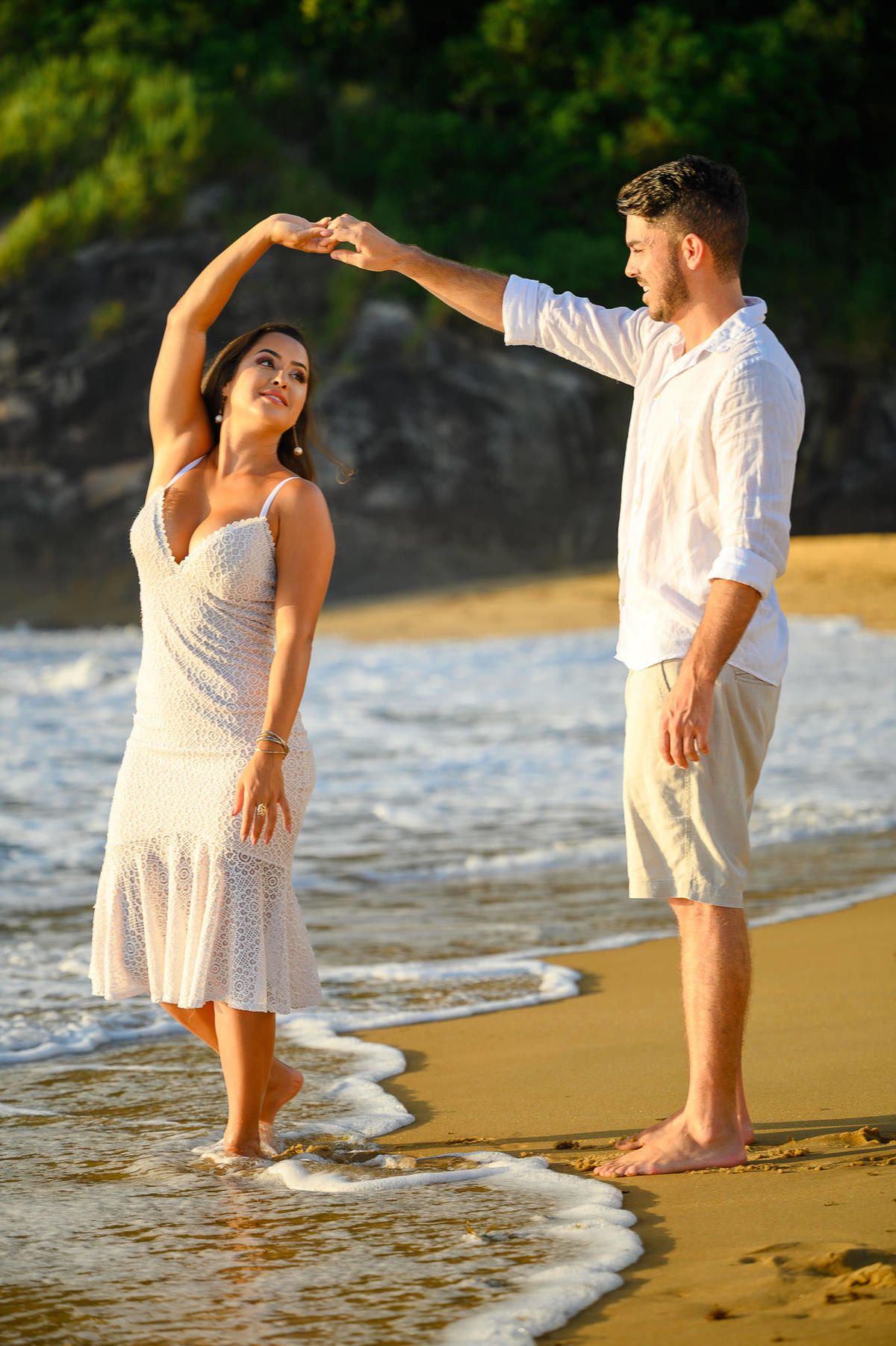 Casal girando e se divertindo na areia durante ensaio de casal em Balneário Cambori