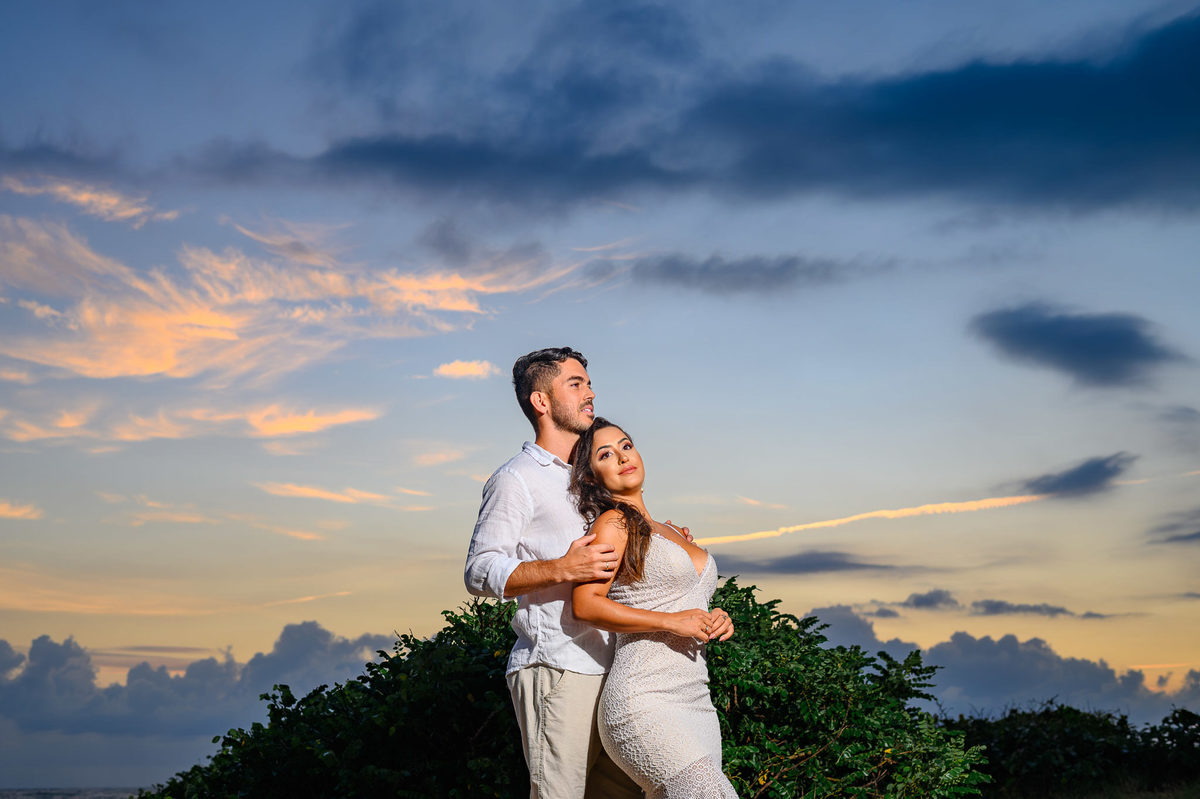 Ensaio de casal na praia em Balneário Camboriú com céu dramático antes do amanhecer