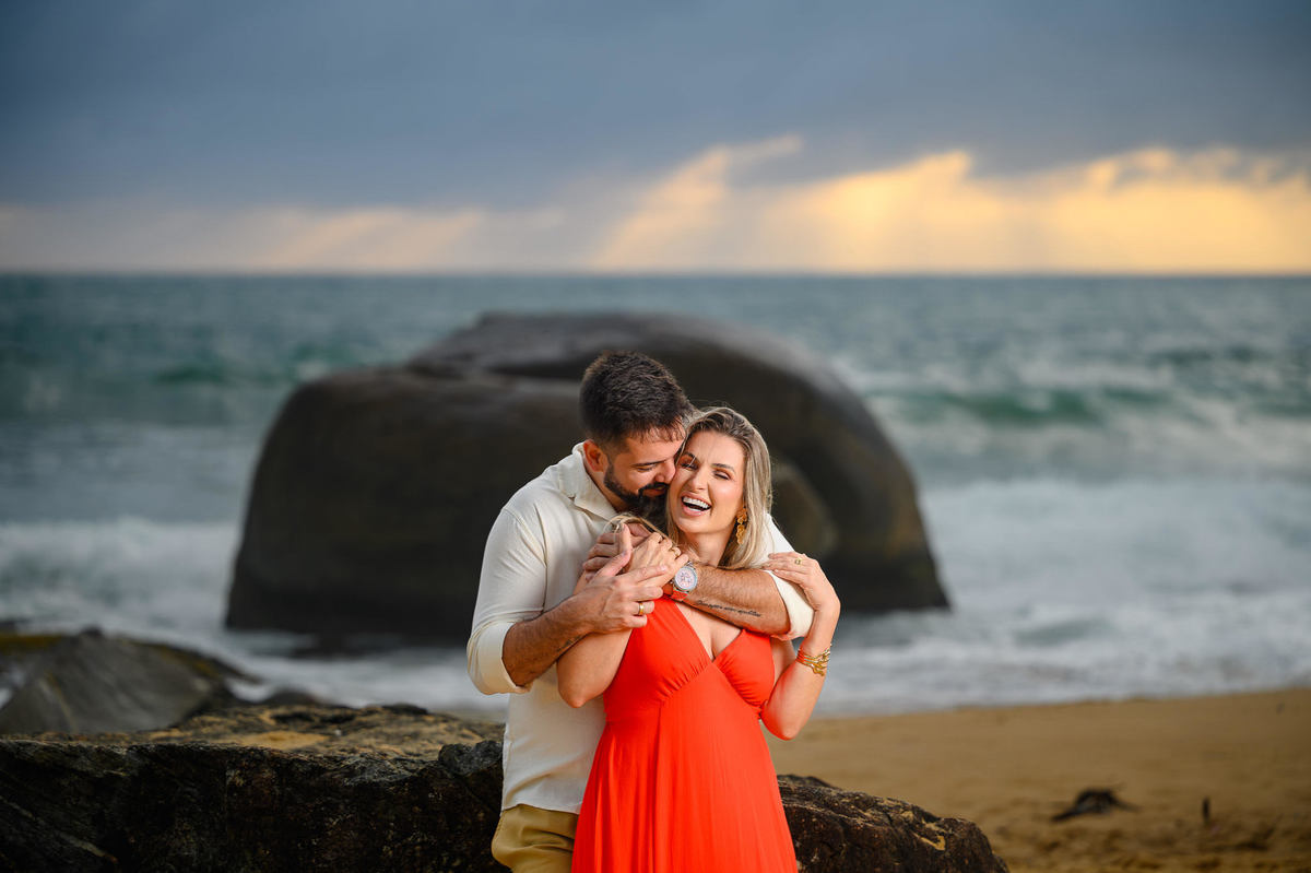 Casal em momento íntimo durante ensaio pré-wedding com o mar ao fundo em SC