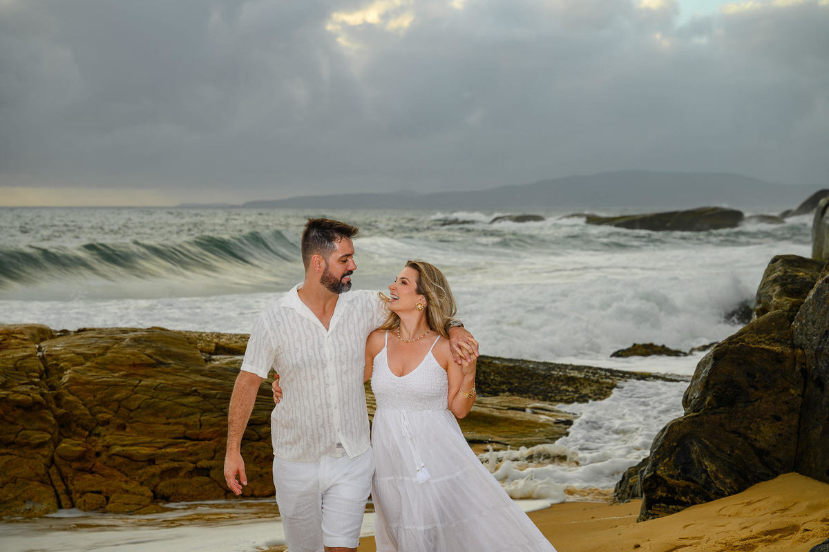 Fotógrafo de pré-wedding registrando casal entre rochas e mar em Santa Catarina