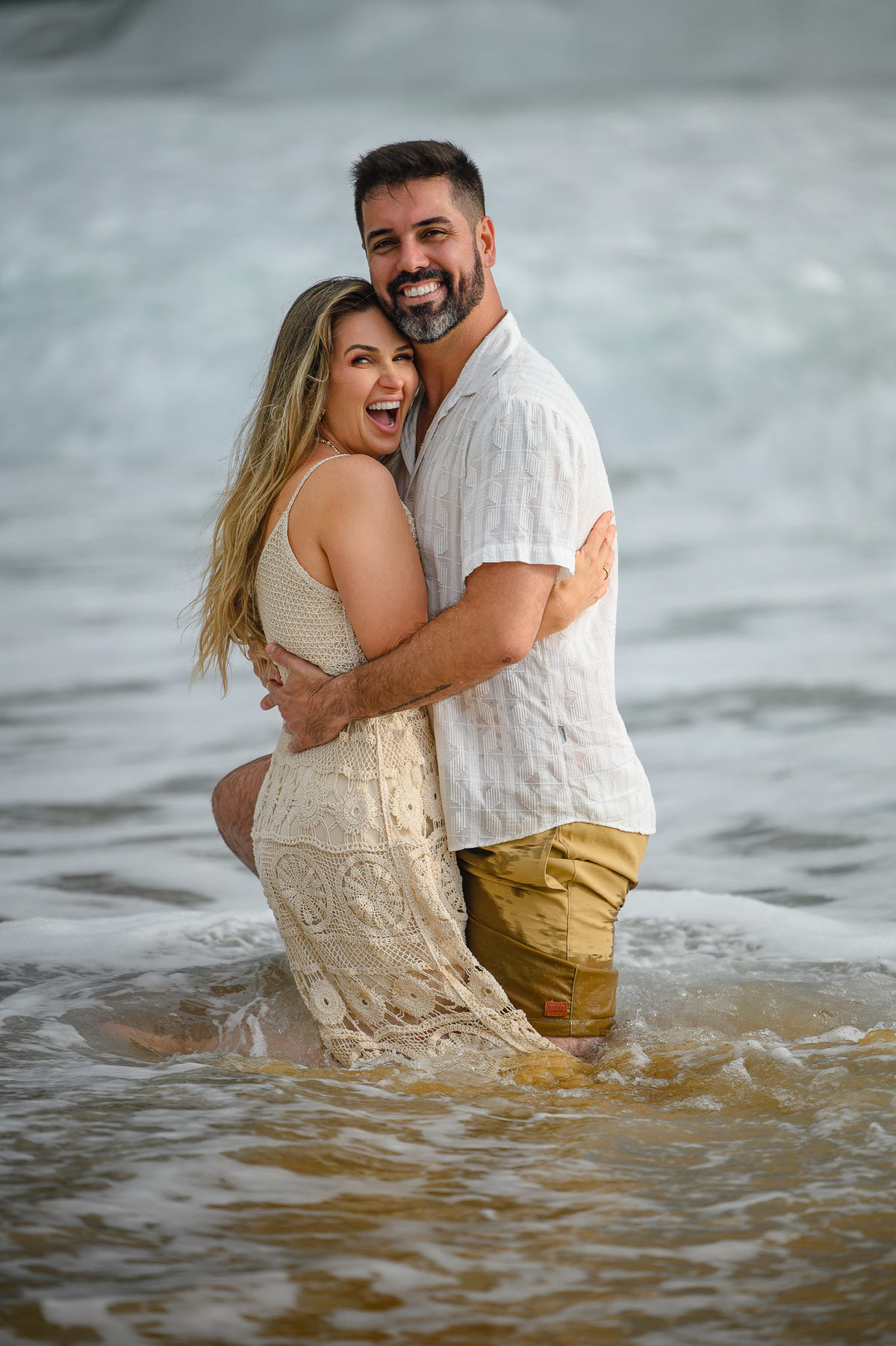 Casal em momento espontâneo durante ensaio fotográfico na praia em SC