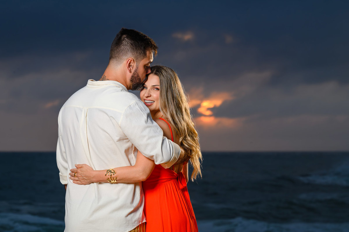 Casal em ensaio pré-wedding na Praia do Estaleirinho em Balneário Camboriú com mar ao fundo