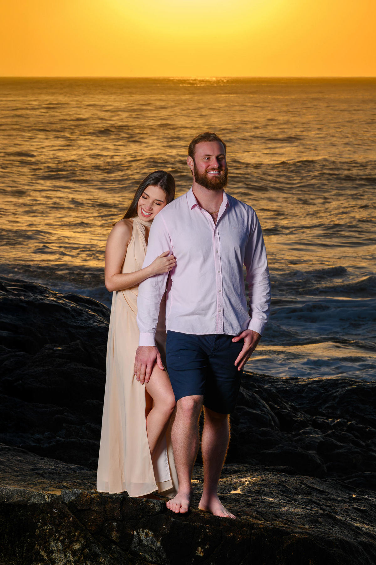 Fotografia de casal abraçado na praia com luz dourada do nascer do sol em Santa Catarina